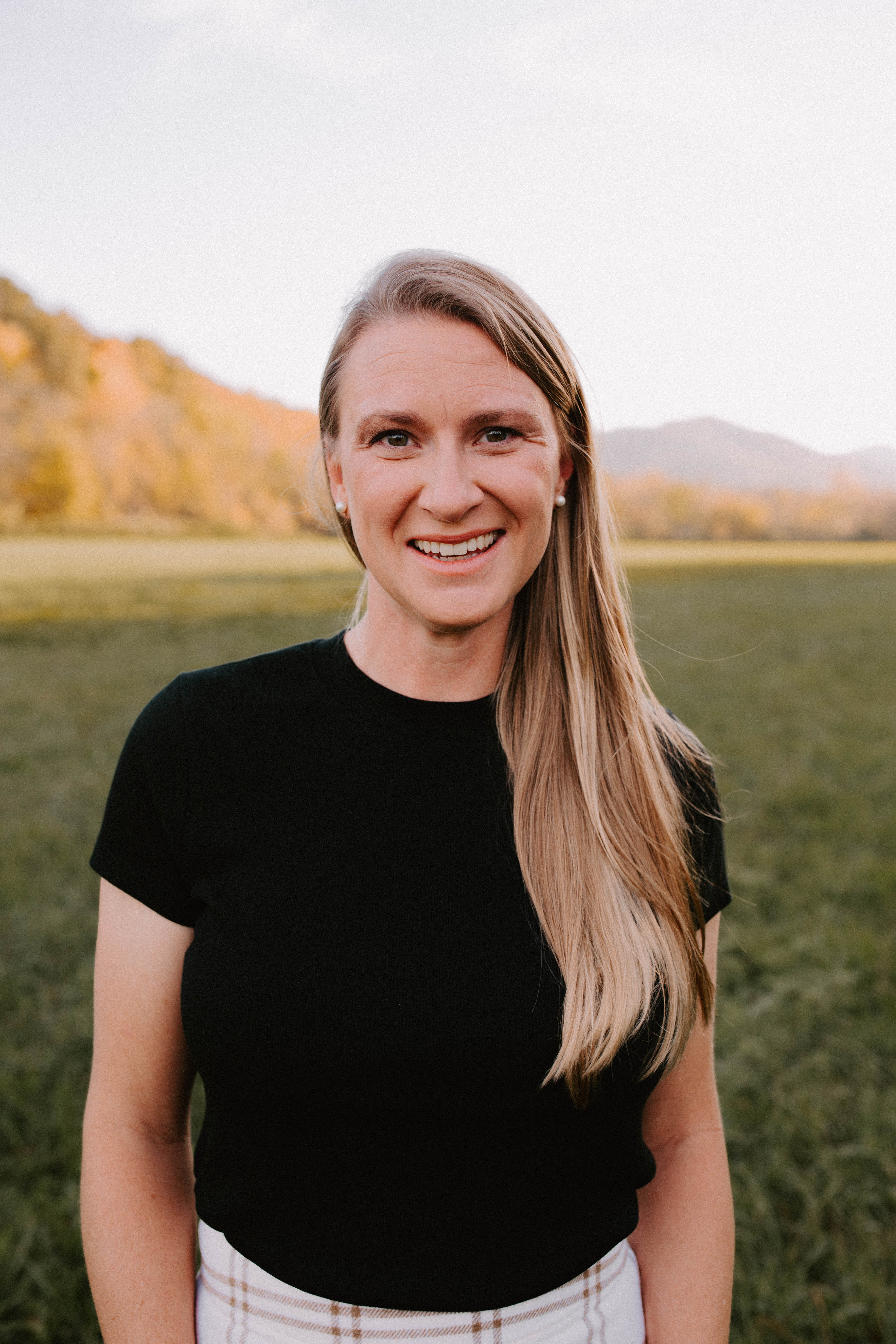 Sara Hawkins tennis coach in greeneville, TN with waist up view and mountains in background